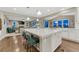 Kitchen featuring a large island with bar seating, white cabinets, and an open view to the living room at 6470 Amur Ct, Castle Rock, CO 80108