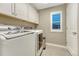 Convenient laundry room with front-load washer/dryer and storage cabinets at 6470 Amur Ct, Castle Rock, CO 80108