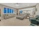 Open-concept living room with plush seating, neutral tones, and seamless access to the kitchen at 6470 Amur Ct, Castle Rock, CO 80108