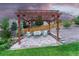 Outdoor pergola with a seating area and stone patio in a well-manicured backyard at 6470 Amur Ct, Castle Rock, CO 80108