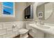 Modern powder room featuring a pedestal sink, elegant fixtures, and stylish wall paneling at 6470 Amur Ct, Castle Rock, CO 80108