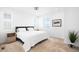 Bright bedroom featuring a large bed, side tables, and a window view at 47 N Uriah St, Aurora, CO 80018