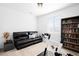 Cozy living room with a black leather couch, modern stationary bike, and stylish bookshelf at 47 N Uriah St, Aurora, CO 80018