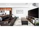 Comfortable living room with a leather couch, a large television, and a modern aesthetic at 47 N Uriah St, Aurora, CO 80018