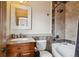Bathroom showcasing granite vanity, decorative mirror, and tiled bathtub with shower at 115 S Jasmine St, Denver, CO 80224