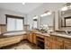 Well-lit bathroom with double vanity, soaking tub, and tiled accents at 115 S Jasmine St, Denver, CO 80224