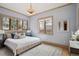 Comfortable bedroom with soft blue walls, hardwood floors and large windows at 115 S Jasmine St, Denver, CO 80224