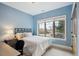 Cozy bedroom with blue walls, large window, and a comfortable bed with decorative pillows at 115 S Jasmine St, Denver, CO 80224
