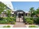 Inviting Lowry Beer Garden entrance with lush landscaping and a charming gate, perfect for outdoor dining and relaxation at 115 S Jasmine St, Denver, CO 80224