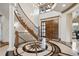 Elegant foyer boasts a spiral staircase, a starburst-patterned floor, and a custom front door at 115 S Jasmine St, Denver, CO 80224