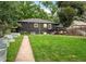 Backyard with green lawn, patio seating area, plantings, and a dark-painted brick exterior at 1218 S University Blvd, Denver, CO 80210