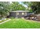 Landscaped backyard features a lush lawn, plantings, patio seating, and dark-painted brick exterior at 1218 S University Blvd, Denver, CO 80210