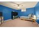 This bedroom offers a cozy space with blue walls, carpet, and natural light from the above-ground window at 1218 S University Blvd, Denver, CO 80210