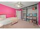 Bright bedroom features pink walls, carpet, closet with shelving, and a unique bed frame at 1218 S University Blvd, Denver, CO 80210