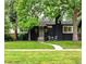 Charming home with a black brick exterior, inviting front yard, and cozy seating area at 1218 S University Blvd, Denver, CO 80210