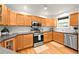 Well-lit kitchen featuring stainless steel appliances, wood cabinets, and sleek countertops at 1218 S University Blvd, Denver, CO 80210