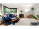 Living room with a vintage brick fireplace, large windows, and a comfortable blue velvet sofa at 1218 S University Blvd, Denver, CO 80210
