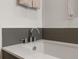 Modern bathroom featuring a soaking tub, stylish chrome fixtures, and gray tiled accent wall at 3233 Tejon St # 305, Denver, CO 80211