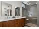 Modern bathroom with dual sinks, wood cabinets, and a glass-enclosed shower at 3233 Tejon St # 305, Denver, CO 80211