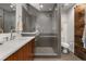 Sleek bathroom with a glass-enclosed shower, wood vanity, gray tiles, and modern fixtures at 3233 Tejon St # 305, Denver, CO 80211