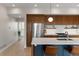 Modern kitchen featuring a large island, stainless steel appliances, wood cabinetry and modern lighting at 3233 Tejon St # 305, Denver, CO 80211