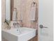 Stylish powder room features a modern floating sink, elegant faucet, and unique patterned wallpaper at 3233 Tejon St # 305, Denver, CO 80211