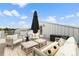 Charming rooftop deck with comfortable lounge furniture, a black umbrella, and scenic surroundings at 3233 Tejon St # 305, Denver, CO 80211