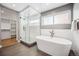 Bright bathroom features a modern soaking tub, tiled shower, and closet at 3615 Lipan St, Denver, CO 80211