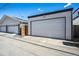 View of the detached two-car garage featuring a light gray paint color and concrete driveway at 3615 Lipan St, Denver, CO 80211