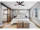 Bright main bedroom features a modern ceiling fan and a sliding barn door to ensuite bathroom at 3615 Lipan St, Denver, CO 80211