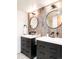 Well-lit bathroom with double sinks, modern fixtures, and a stylish wood accent wall at 18910 Augusta Dr, Monument, CO 80132