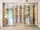 A modern wine cellar with stone walls and glass doors, showcasing wine racks and storage at 18910 Augusta Dr, Monument, CO 80132