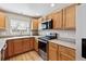 A modern kitchen with stainless steel appliances and light wood cabinets at 9471 Crossland Way, Highlands Ranch, CO 80130