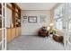 A cozy room with built in bookcase, comfortable chair, and natural light at 9471 Crossland Way, Highlands Ranch, CO 80130