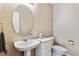 Cozy powder room features pedestal sink, oval mirror, and neutral paint at 9471 Crossland Way, Highlands Ranch, CO 80130