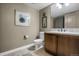 Half bath featuring a wood vanity, soft neutral paint, and decorative wall art at 85 Rampart Way # 206, Denver, CO 80230