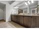 Double vanity bathroom featuring granite counters, dark wood cabinetry, and decorative fixtures at 85 Rampart Way # 206, Denver, CO 80230