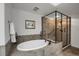 Stylish bathroom with soaking tub, frameless glass shower, and neutral tile flooring at 85 Rampart Way # 206, Denver, CO 80230