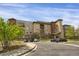 Exterior shot of condo building and parking area, showing a well-designed landscape at 85 Rampart Way # 206, Denver, CO 80230