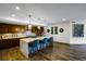 Open kitchen with an island, pendant lighting, blue chairs and wood-style flooring at 85 Rampart Way # 206, Denver, CO 80230