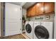 Convenient laundry room features a washer, dryer, and ample cabinet space for storage at 85 Rampart Way # 206, Denver, CO 80230