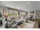 Bright living room with large sectional sofa, area rug, and abundant natural light from large windows at 85 Rampart Way # 206, Denver, CO 80230
