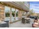 Charming outdoor patio with dining table, chairs and a view of the landscaped surroundings at 85 Rampart Way # 206, Denver, CO 80230