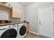 Convenient laundry room with modern washer/dryer, folding counter, and overhead cabinets at 2460 Switch Grass Way, Castle Rock, CO 80109
