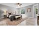 Bright bedroom features a decorative rug, ceiling fan, and a large window providing plenty of natural light at 11757 W Tufts Pl, Morrison, CO 80465