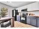 Modern kitchen with white and navy cabinets, butcher block counters, and stainless steel appliances at 11757 W Tufts Pl, Morrison, CO 80465