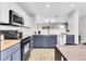 Modern kitchen with white and navy cabinets, butcher block counters, and stainless steel appliances at 11757 W Tufts Pl, Morrison, CO 80465