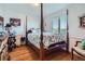 This bedroom features hardwood floors, a four-post bed, and a window with a view at 5251 Altura St, Denver, CO 80239