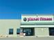 This image features the exterior of a Planet Fitness location with its branding and entrance visible under a clear blue sky at 5251 Altura St, Denver, CO 80239