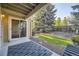 Back patio with sliding doors offering a view of the backyard with grass and trees at 8208 S High Ct, Centennial, CO 80122